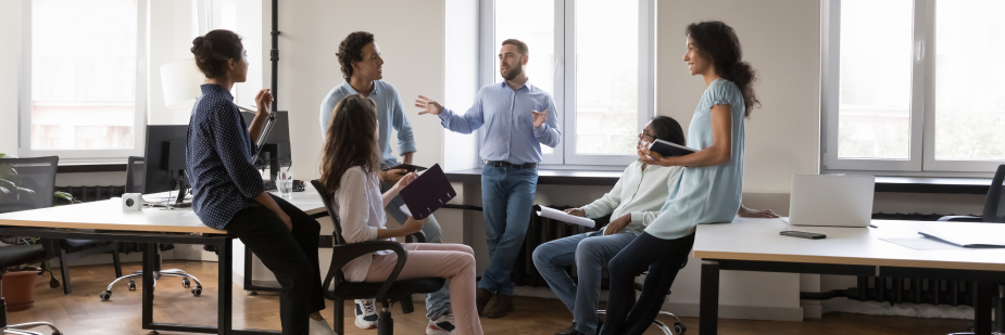 Grupo de cinco pessoas em um escritório. Eles ouvem um homem falar. reconhecido e promovido no trabalho.