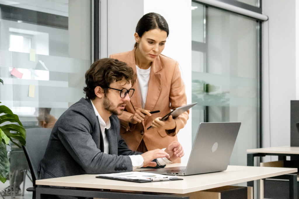 Mulher auxiliando homem no trabalho. Importância da mentoria.