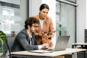 Mulher auxiliando homem no trabalho. Importância da mentoria.