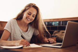 Mulher estudando em uma cafeteria. Cursar a pós-graduação online da UPF de qualquer lugar