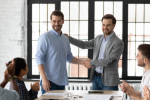 Homem sendo reconhecido por promoção. Quem tem pós-graduação ganha mais