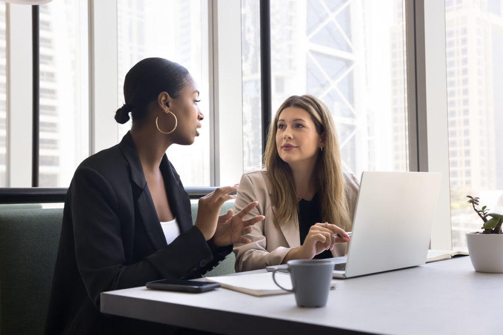 Mulher conversando com colega de trabalho. Melhorar sua comunicação interpessoal.
