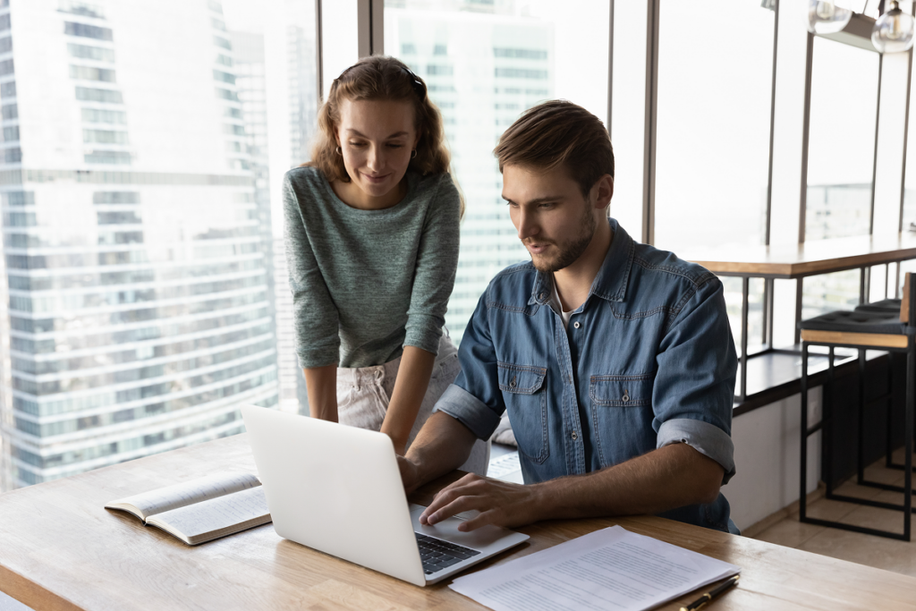 Homem e mulher trabalhando juntos no computador. Promover a autonomia na sua equipe.